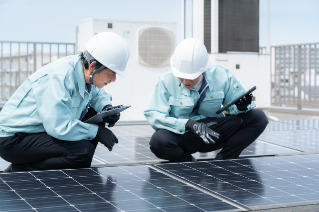 作業員が太陽光パネルを点検する様子